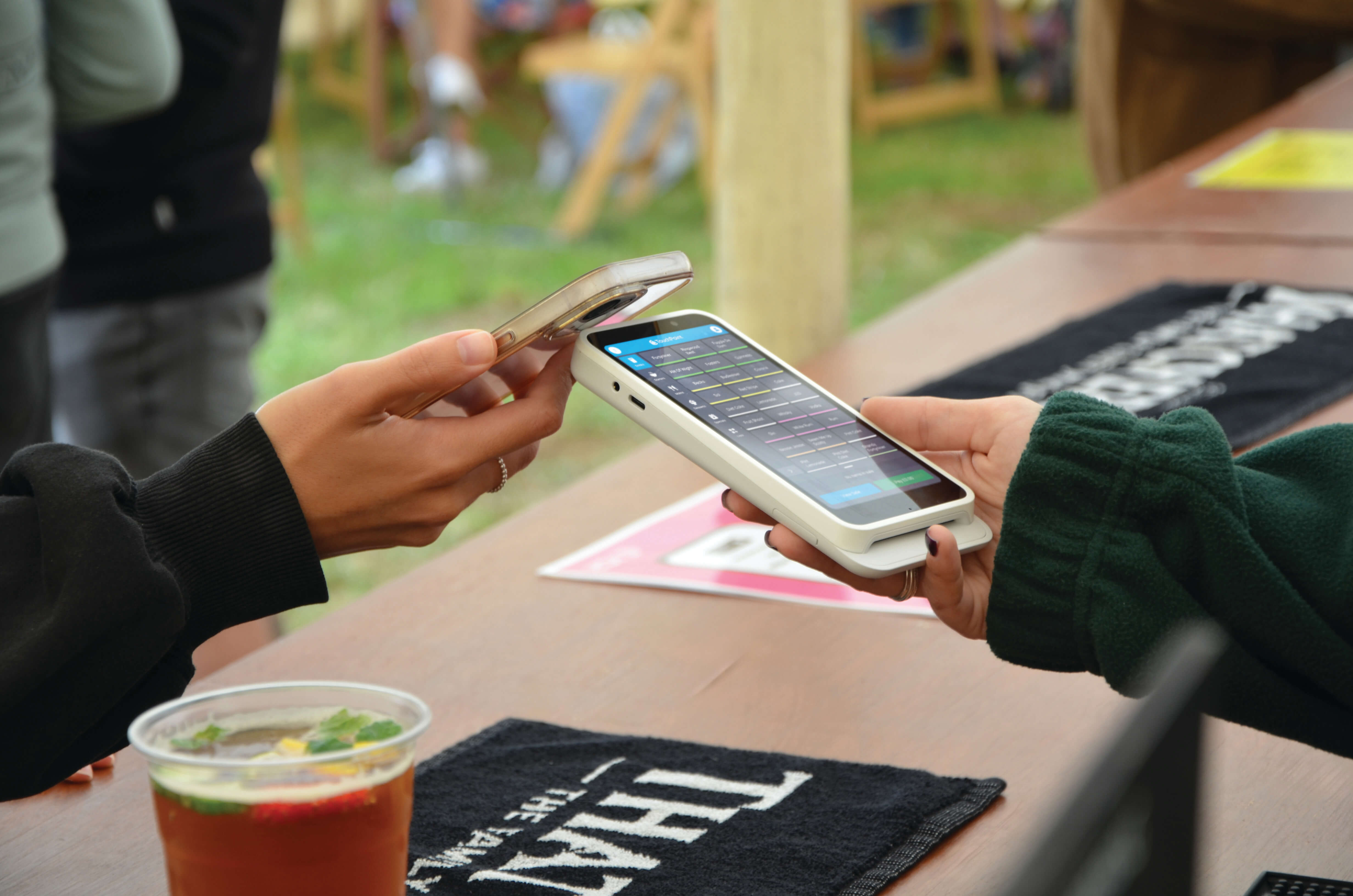 A person using their phone to pay for drinks